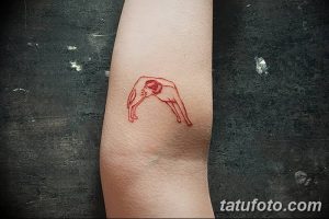 Фото минималистичной татуировки, изображающей фигуру человека, изогнутого в форме арки. Красный рисунок татуировки на коже.