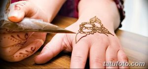 Фото тату мехенди: процесс нанесения рисунка хной на руку, с использованием специального конуса и демонстрацией мастерства художника.