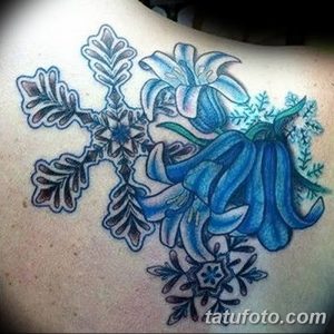 Фото тату: Оригинальная татуировка с сочетанием синих колокольчиков и ажурных снежинок на женской лопатке. Красивый и необычный рисунок.