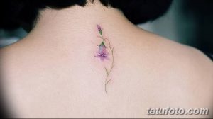 Фото тату колокольчика на шее. Нежный и минималистичный рисунок, выполненный в акварельном стиле с использованием пастельных оттенков.