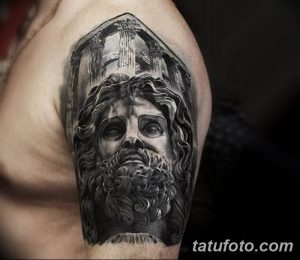 Фото тату на плече: черно-серая татуировка головы Зевса на фоне древних колонн, выполненная в реалистичной технике с высокой детализацией.