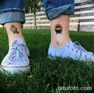 Фото двух миниатюрных татуировок на лодыжках: лепрекон и горшок с золотом, выполненные в ярких, мультяшных цветах.