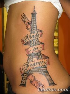 Фото тату Эйфелевой башни на боку с надписью 'Made in France'. Черно-белый рисунок татуировки в стиле олдскул.