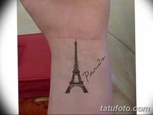 Фото тату Эйфелевой башни и надписи "Paris" на запястье. Нежный и романтичный рисунок татуировки, выполненный в черном цвете.