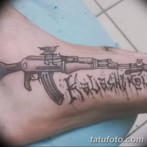 Фото тату на руке с изображением автомата Калашникова и надписями на кириллице. Простой и лаконичный рисунок татуировки.