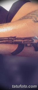 Фото тату черного автомата Калашникова на руке. Простой и лаконичный рисунок татуировки, выполненный в графическом стиле.