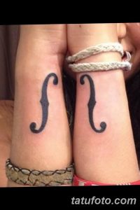 Фото парных татуировок на запястьях с изображением символа 'f'. Татуировки выполнены тонкими черными линиями и расположены симметрично на обоих запястьях.