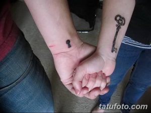 Парная татуировка на запястьях: на одной руке изображена замочная скважина, на другой – ключ. Черно-серые татуировки символизируют связь и единство.