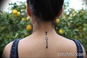Фото тату на шее: маленький черный ключ, выполненный в минималистичном стиле, с четкими линиями и простым дизайном.