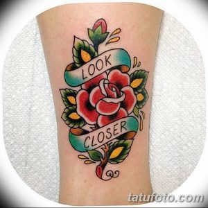 Фото тату с изображением красной розы и надписи "LOOK CLOSER" на предплечье в стиле олд скул. Яркий и запоминающийся рисунок.