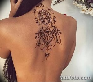 Фото тату: Большая татуировка лотоса на спине, выполненная в декоративном стиле с использованием тонких линий и узоров. Элегантный и сложный дизайн.