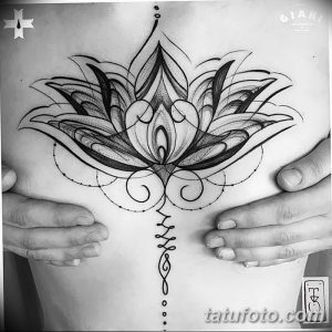 Фото тату: Большой цветок лотоса в стиле blackwork, расположенный на груди. Детализированный рисунок с геометрическими элементами и точками.