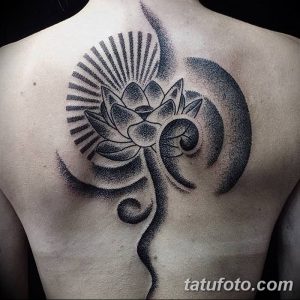 Фото татуировки лотоса на спине, выполненной в технике dotwork. Черно-белый рисунок, множество точек и геометрические элементы.