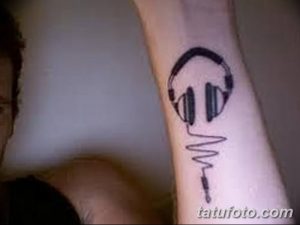 Фото минималистичной татуировки на руке: наушники, переходящие в кардиограмму, символизирующие ритм жизни.