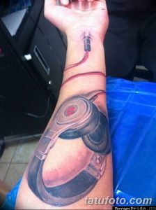 Фото тату на запястье: реалистичное изображение современных наушников с красным проводом. Детализированная проработка и тени.