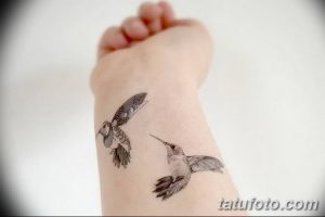 Фото тату двух колибри на запястье. Детализированный рисунок татуировки в черно-серых тонах, имитирующий карандашный эскиз.