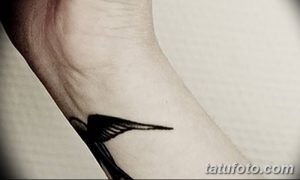 Фото тату черного ворона на запястье. Лаконичный рисунок татуировки с четкими линиями, выполненный в стиле минимализм.