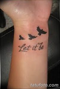 Фото тату на предплечье: три летящие птицы и надпись 'Let it be', выполненные в черном цвете.