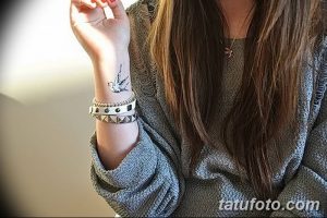 Фото тату ласточки, выполненной в технике графики на запястье. Черно-белая татуировка, тонкие линии, детализированный рисунок.