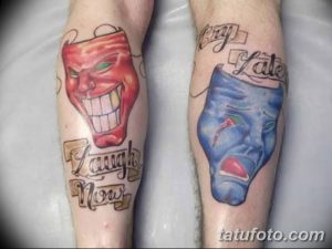 Фото тату: цветной рисунок смеющейся и плачущей маски с надписью 'Laugh Now Cry Later' на голенях.