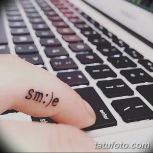 Фото тату надписи 'smile' на пальце. Простая и стильная татуировка с позитивным смыслом.