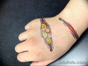 Фото тату: реалистичное изображение рвущейся кожи на руке, из-под которой видны смайлики. Оригинальный и шокирующий рисунок татуировки.