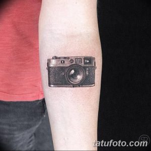 Фото тату: реалистичное изображение старинного фотоаппарата в черно-белой гамме на предплечье. Идеальный рисунок татуировки для фотографов.