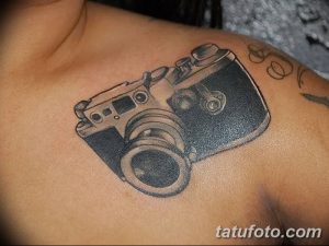 Фото тату винтажного фотоаппарата на груди, выполненного в черно-серых тонах с высокой детализацией.