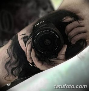Необычная татуировка фотоаппарата, интегрированного в кожу руки. Реалистичный рисунок с элементами сюрреализма и детализированной проработкой.