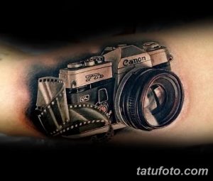 Фото реалистичной тату фотоаппарата Canon с размотанной кинопленкой. Детализированный и объемный рисунок татуировки на руке.