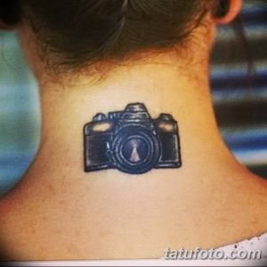 Фото миниатюрной тату фотоаппарата на затылке. Небольшой, но выразительный рисунок татуировки в черном цвете.
