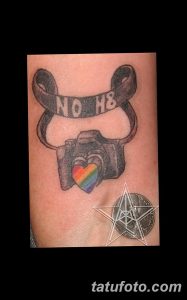 Фотография татуировки фотоаппарата с надписью "NO H8" и радужным сердцем. Символ поддержки ЛГБТ-сообщества.