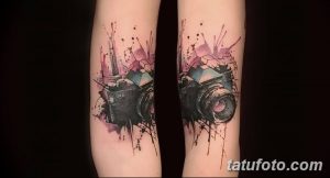 Фото тату: акварельный рисунок фотоаппарата на ногах. Яркие брызги краски и размытые контуры создают эффект легкости.