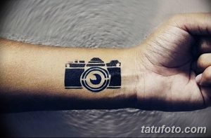 Фото тату: простой черный рисунок фотоаппарата на запястье. Идеально для любителей минимализма и фотографии.