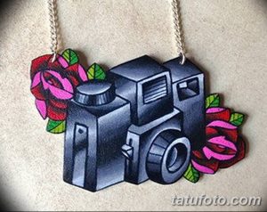 Фото тату винтажной камеры, украшенной розами на плече. Черно-белый рисунок татуировки в стиле реализм.