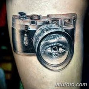 Фото тату реалистичного фотоаппарата, объектив которого заменен на человеческий глаз. Детальный и оригинальный рисунок татуировки.