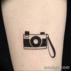 Фото тату минималистичного чёрного фотоаппарата на ноге. Простой и лаконичный рисунок, выполненный чёткими линиями.