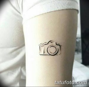 Фото тату простого контурного изображения фотоаппарата на руке. Изображение выполнено в минималистичном стиле.