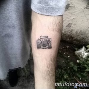 Простая татуировка в виде контура фотоаппарата на предплечье. Минималистичный рисунок тату для любителей лаконичного дизайна.