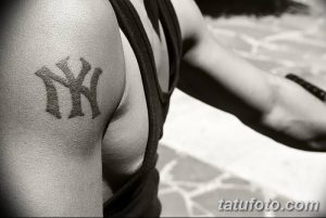 Фото тату на плече: логотип бейсбольной команды New York Yankees. Простой и лаконичный рисунок татуировки в черно-белом цвете.