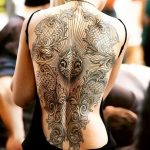 Фото тату: сложный орнамент в стиле барокко на женской спине, выполненный в черно-серых тонах с высокой детализацией и геометрическими элементами.
