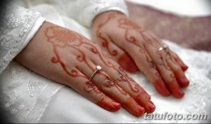 Фото тату мехенди на руках невесты, выполненное в традиционном стиле с использованием коричневых оттенков хны. Детализированный рисунок с цветочными и геометрическими элементами.