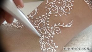 Фото тату белой мехенди на руке, демонстрирующее сложный узор с цветочными мотивами и тонкими линиями. Идеально для вдохновения и поиска эскизов.