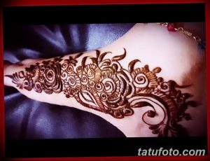 Фото тату мехенди на стопе, выполненное в традиционном стиле с использованием коричневых оттенков. Детализированный узор украшает верхнюю часть стопы.
