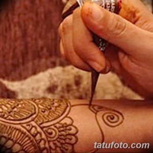 Фото процесса нанесения тату хной на руку, демонстрирующее работу мастера и тонкость линий. Идеально для тех, кто интересуется техникой мехенди.