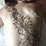 Фото тату хной на спине женщины, с детальным узором в восточном стиле, выполненным коричневой краской. Идеально для вдохновения и поиска идей.