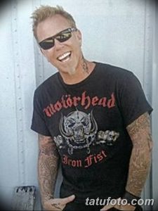 Фотография Джеймса Хетфилда из Metallica в повседневной одежде и с татуировками на руках. Он улыбается и смотрит в камеру.