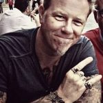 Фотография Джеймса Хетфилда из Metallica, показывающая его повседневный образ. Видны татуировки на руках и пальцах.