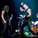 Фотография Джеймса Хетфилда и Кирка Хэмметта из Metallica во время энергичного живого выступления на сцене. Видны татуировки на руках Джеймса Хетфилда.