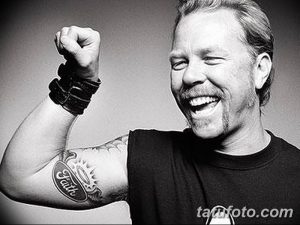 Фотография татуировки 'Faith' на предплечье Джеймса Хетфилда, вокалиста Metallica. Черно-белое изображение с четкой прорисовкой букв и декоративных элементов.